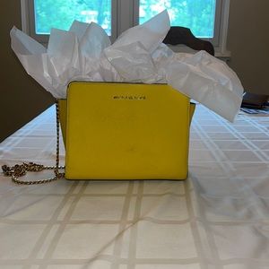 This yellow Micheal Kors bag has some dirt on the front of the bag.